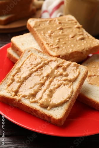 Delicious toasts with peanut butter on table, closeup