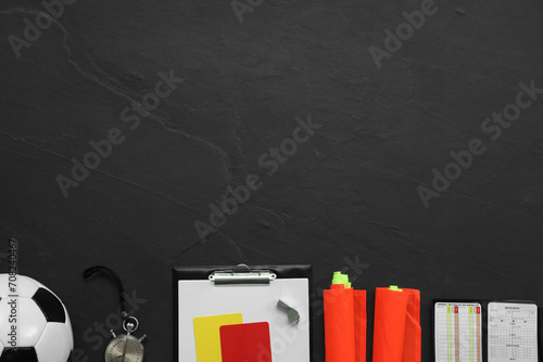 Different referee equipment on black table, flat lay. Space for text photo