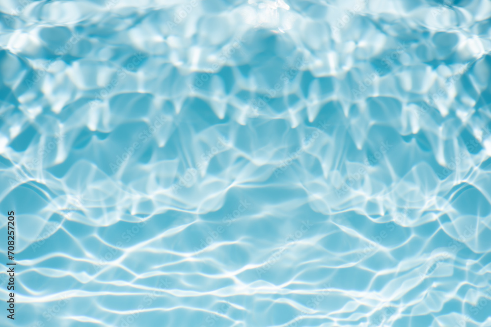 Fototapeta premium Bluewater waves on the surface ripples blurred. Defocus blurred transparent blue colored clear calm water surface texture with splash and bubbles. Water waves with shining pattern texture background.