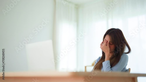Office syndrome. Overworked tired young asian woman feeling headache, having eyesight problem after computer laptop work. Stressed young woman suffering from fatigue at home photo
