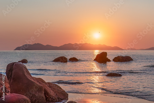 Canvas Print Sunrise over islands and rocks with reflection on the water at Rose Bay in Bowen in the Whitsunday region of tropical Queensland, Australia