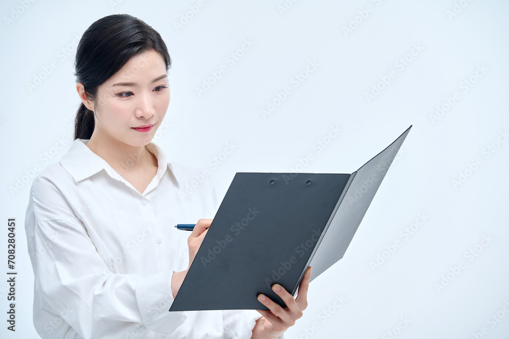 A beautiful Asian woman is making various facial expressions and gestures while holding a document file and a ballpoint pen for business. A beautiful Asian woman is making various facial expressions and gestures while holding a document file and a ballpoint pen for business.