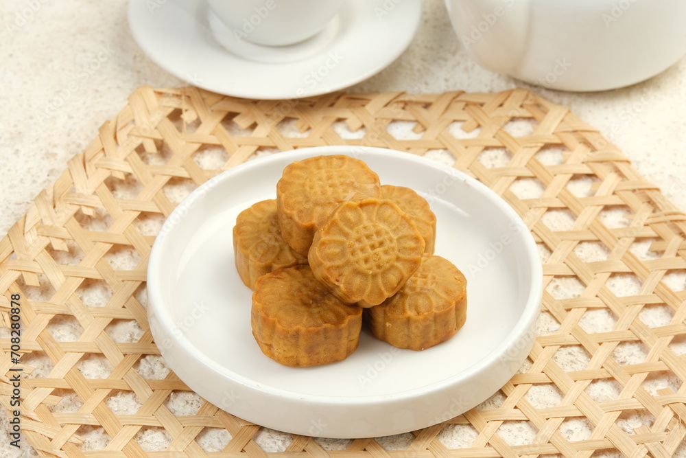 Mini Mooncake, Moon cake (yue bing }-Chinese Traditional Pastry With Tea Cups on White Background, Mid-Autumn Festival Concept, Close Up. Mini Mooncake, Moon cake (yue bing }-Chinese Traditional Pastry With Tea Cups on White Background, Mid-Autumn Festival Concept, Close Up.