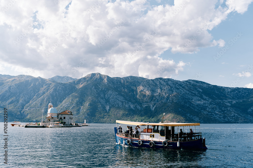 Excursion boat sails along the Bay of Kotor to the island of Gospa od Skrpjela. Montenegro