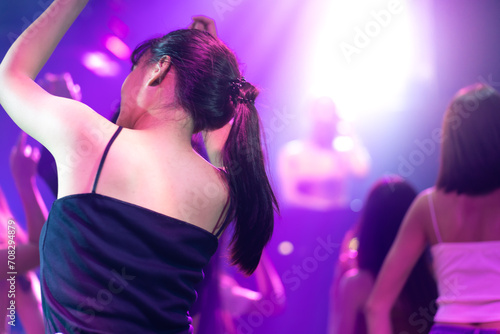 Asian thai girl drinking in night club. diverse young people dancing in night club. Nightlife and disco dance party concept. Fun music festival