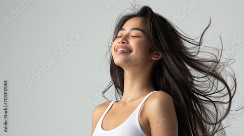Captivating Snapshot of a Long-Haired Woman Blissfully Closing Her Eyes in Pure Delight Against a Mesmerizing Background