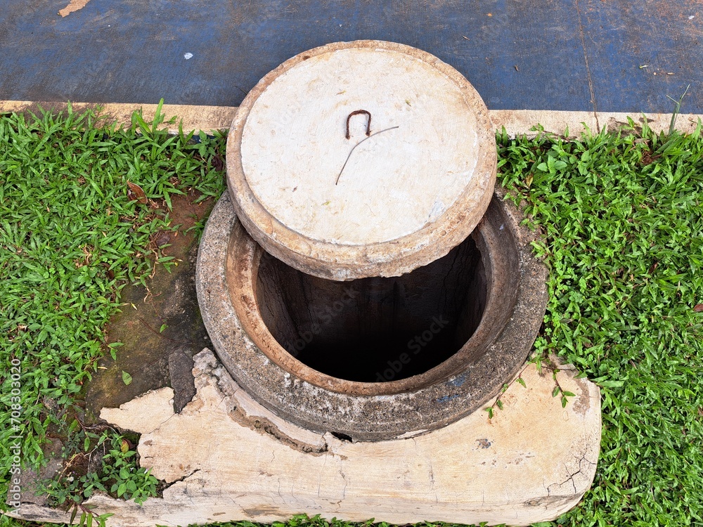 The hole cover leading to the gutter is made of cement The hole cover leading to the gutter is made of cement