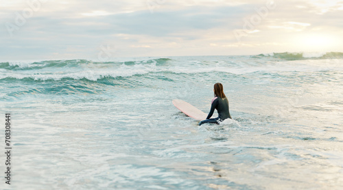 Surfing  beach and woman on surfboard in ocean for water sports  fitness and freedom in morning. Nature  travel and person on tropical holiday  vacation and adventure by sea for fun  hobby and relax