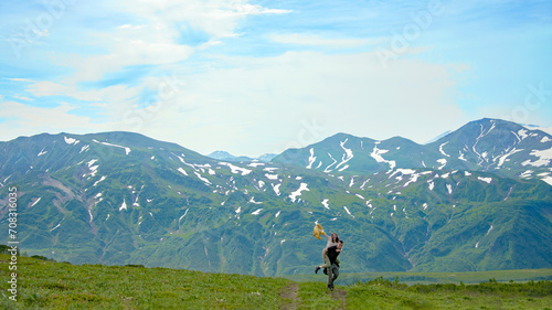 There are man and woman on the foreground. They are happy. There is a Vilyucha valley on the background.