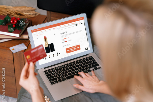 Young woman using laptop with credit card for internet banking, online shopping E commerce by online payment gateway at home. Modern and convenience online shopping with debit card. Blithe