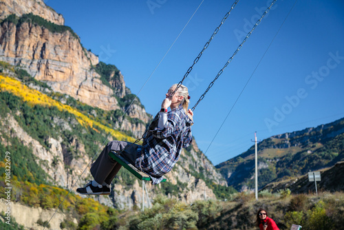 Girl swinging on a swing in the mountains