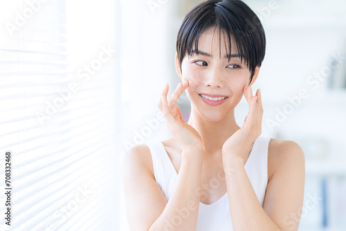 部屋でスキンケアをする若い女性 photo