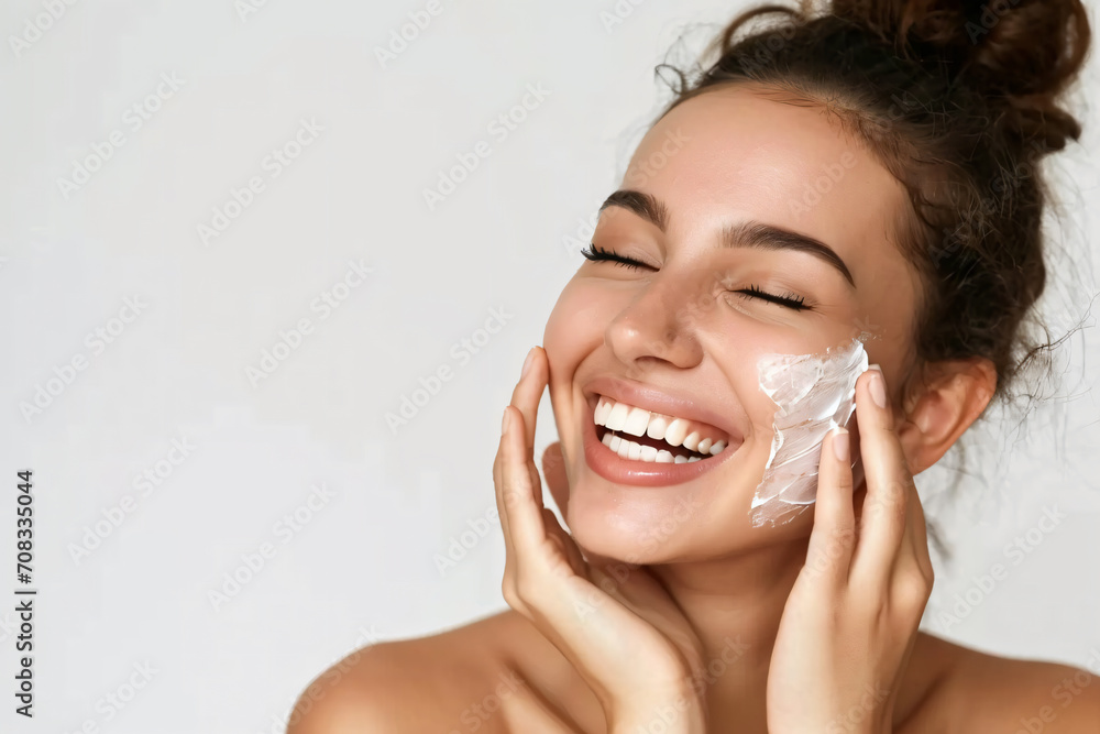 Close-up beauty portrait of a Lady with happiness applying a bit of face cream.Happy emotional daily routine, anti-aging, wrinkle reduction cosmetic theme. - obrazy, fototapety, plakaty 
