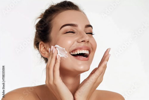Close-up beauty portrait of a Lady with happiness applying a bit of face cream.Happy emotional daily routine, anti-aging, wrinkle reduction cosmetic theme. photo
