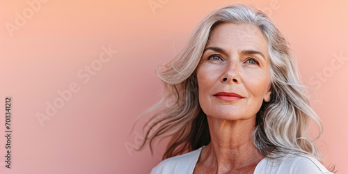 Close up of a confident middle aged woman with a peach copyspace background