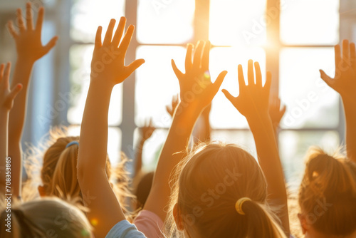 Young kids students raising their hands in class at the elementary school