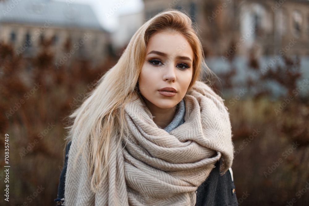 Beautiful elegant fashion girl model in a fashionable beige scarf outdoors Beautiful elegant fashion girl model in a fashionable beige scarf outdoors