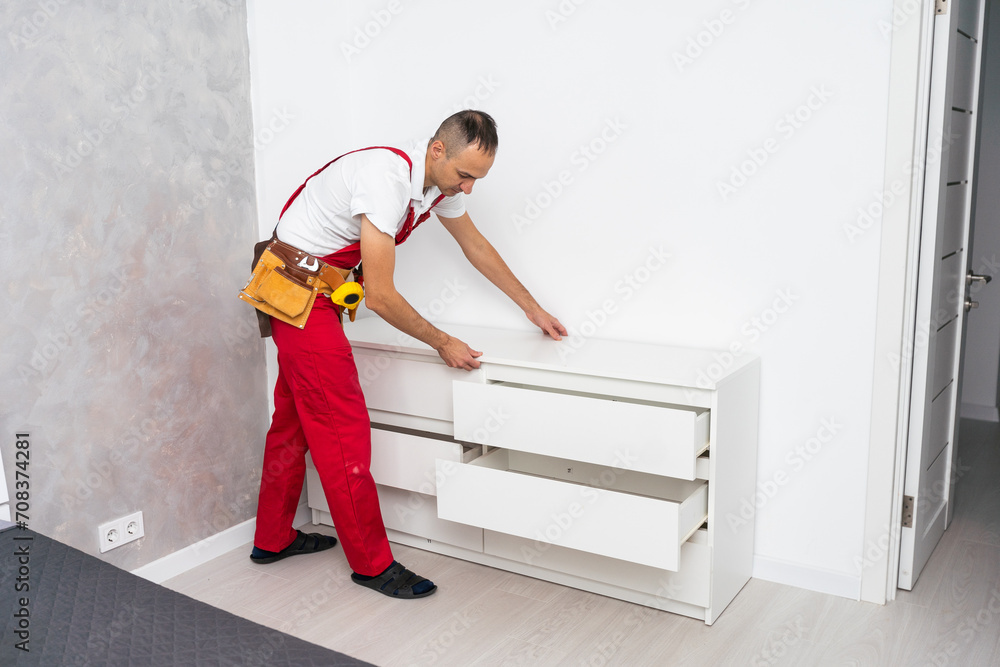 Professional furniture assembly and repair concept. Contractor repairman assembling furniture, indoors Professional furniture assembly and repair concept. Contractor repairman assembling furniture, indoors