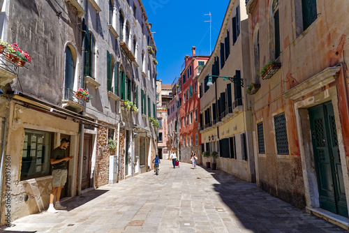 Old town of Italian City of Venice with alley with colorful weathered facades on a summer day. Photo taken August 6th, 2023, Venice, Italy.