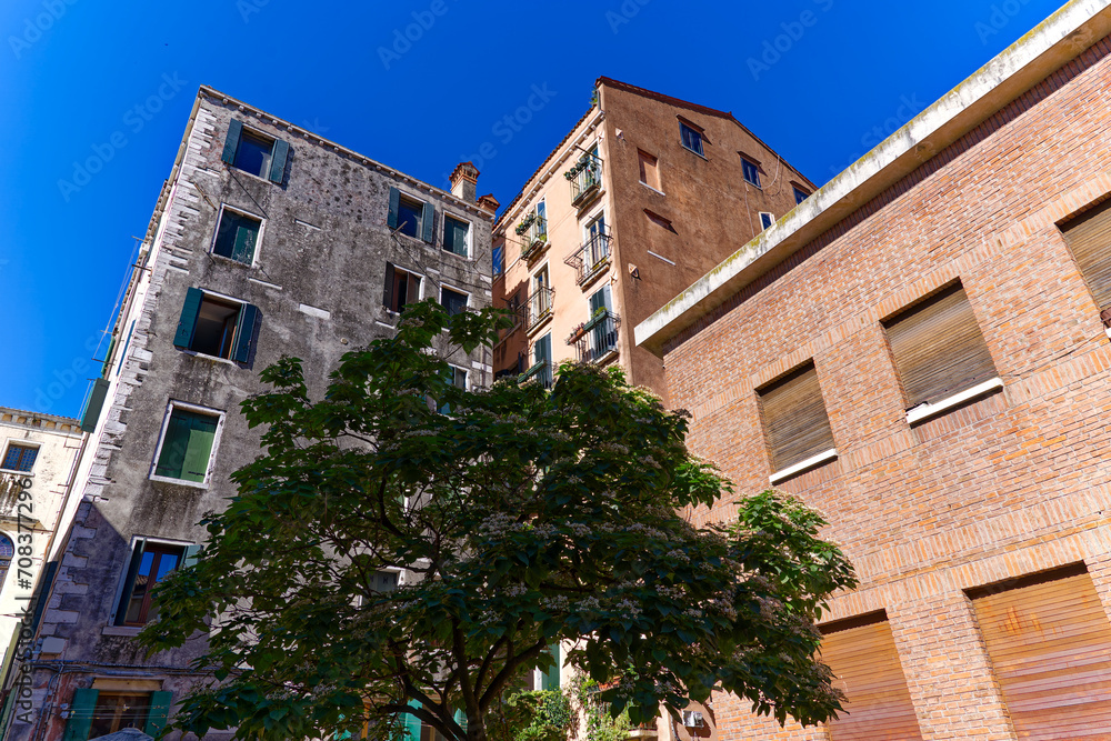 Looking up weathered facades of apartment buildings at Ghetto Vecchio at the old town of Italian City of Venice on a sunny summer day. Photo taken August 7th, 2023, Venice, Italy.