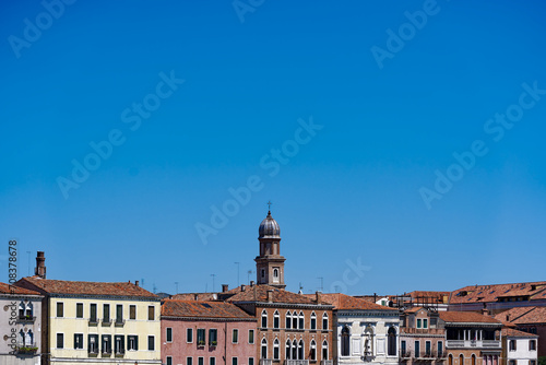 Old town of Italian City of Venice with colorful facades of historic houses and church tower seen from Canale san Giorgio on a sunny summer day. Photo taken August 7th, 2023, Venice, Italy.