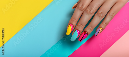 Multi-colored pastel manicure combined tone on tone with a striped background.Nail art. Female hands with trendy colorful French manicure are lying on bright multicolored background. Copy space  photo