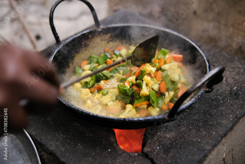 woman stirring mixed fried vegetables 