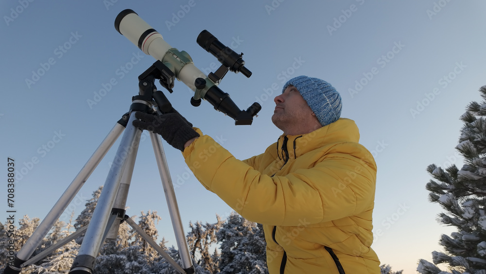 Amateur astronomer looking at the Sun through a telescope with special solar filter.
