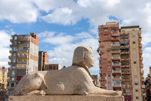 Sphinx near Pompey's pillar on territory of Serapeum of Alexandria against residential buildings