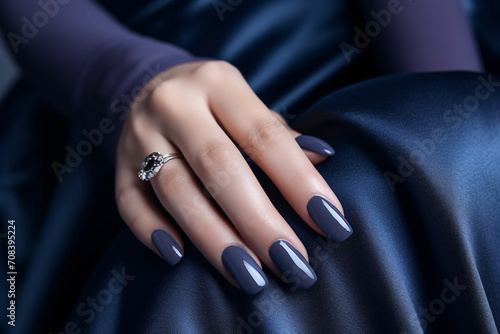 Glamour woman hand with navy blue nail polish on her fingernails. Navy nail manicure with gel polish at luxury beauty salon. Nail art and design. Female hand model. French manicure.