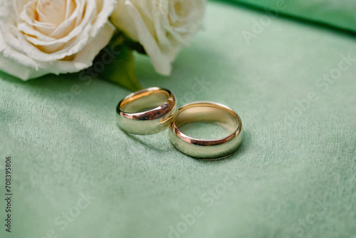 Two simple wedding rings resting on a precious green fabric