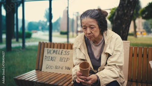 Desperate homeless old woman checking empty paper cup for donations, injustice photo
