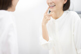 鏡を見ながら歯をチェックするミドル世代女性
