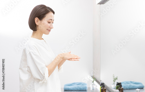 オイルを手にとり馴染ませている女性/ヘアケア photo