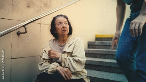 Female volunteer talks with lonely homeless woman sitting on stairs, support photo
