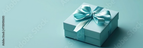 Minimalistic teal gift box with a sleek ribbon, perfect contrast on a soft green background © olga_demina