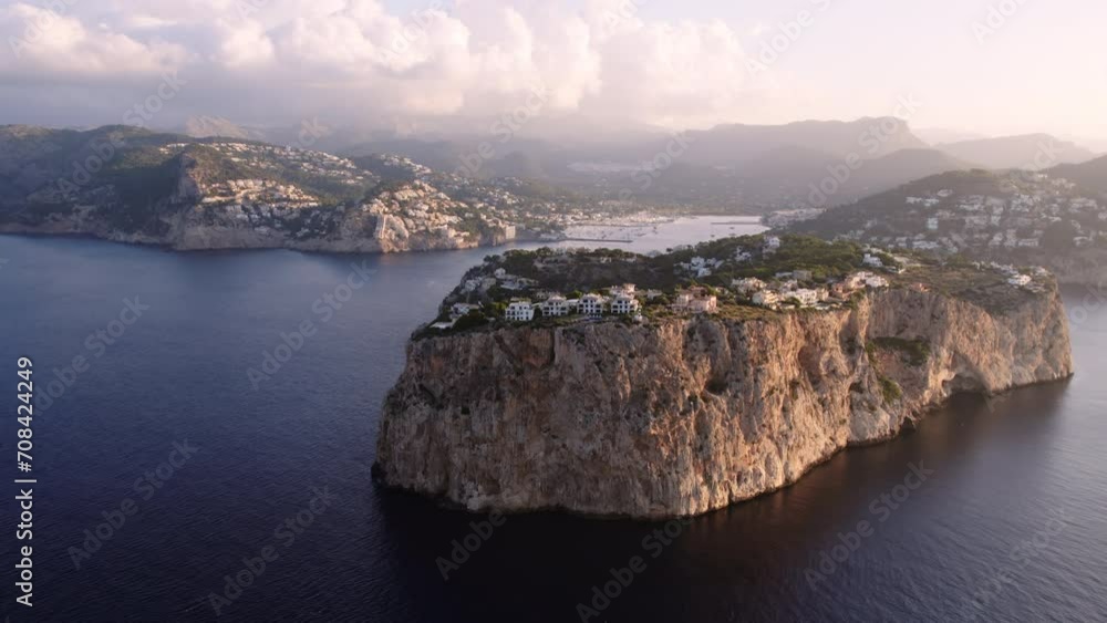 Epic cliff in the sea or peninsula in Mallorca with residential houses on top, luxurious real estate development with vacation homes and holiday villas. mediterranean travel destination Epic cliff in the sea or peninsula in Mallorca with residential houses on top, luxurious real estate development with vacation homes and holiday villas. mediterranean travel destination