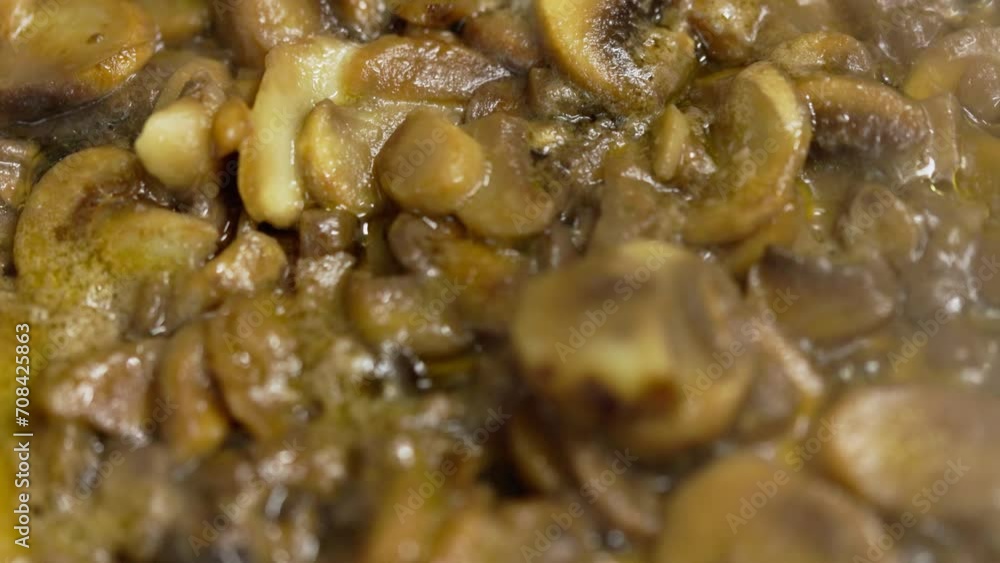 frozen champignon mushrooms boiling in a frying pan, slow motion closeup. frozen champignon mushrooms boiling in a frying pan, slow motion closeup.