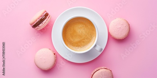 Top view of cup of coffee with macaron on pink background. Minimalist concept of food.