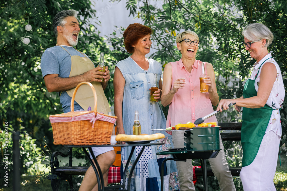 Obraz premium Elderly people are making barbeque, drinking beverages, making memories, and laughing.