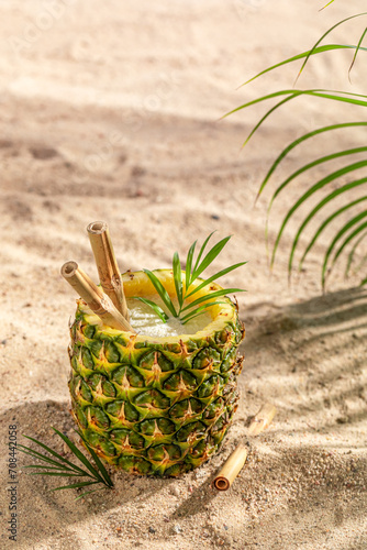 Delicious pinacolada in pineapple served with a bamboo straw.