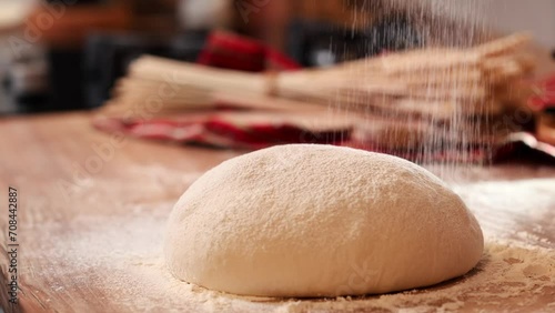 sprinkle flour on the dough. 4k video while preparing the bread sourdough for the first rise. wheat flour sprinkled. bread cooking at home. photo