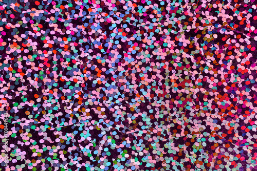 macro photo of cool pink rainbow holographic dot foil material, colorful hologram surface, glitter pixel pattern background. © Simon