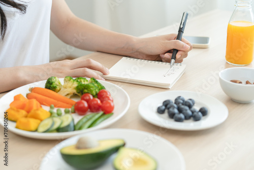 the person planning daily menu during dieting and writing diary to motivate. photo