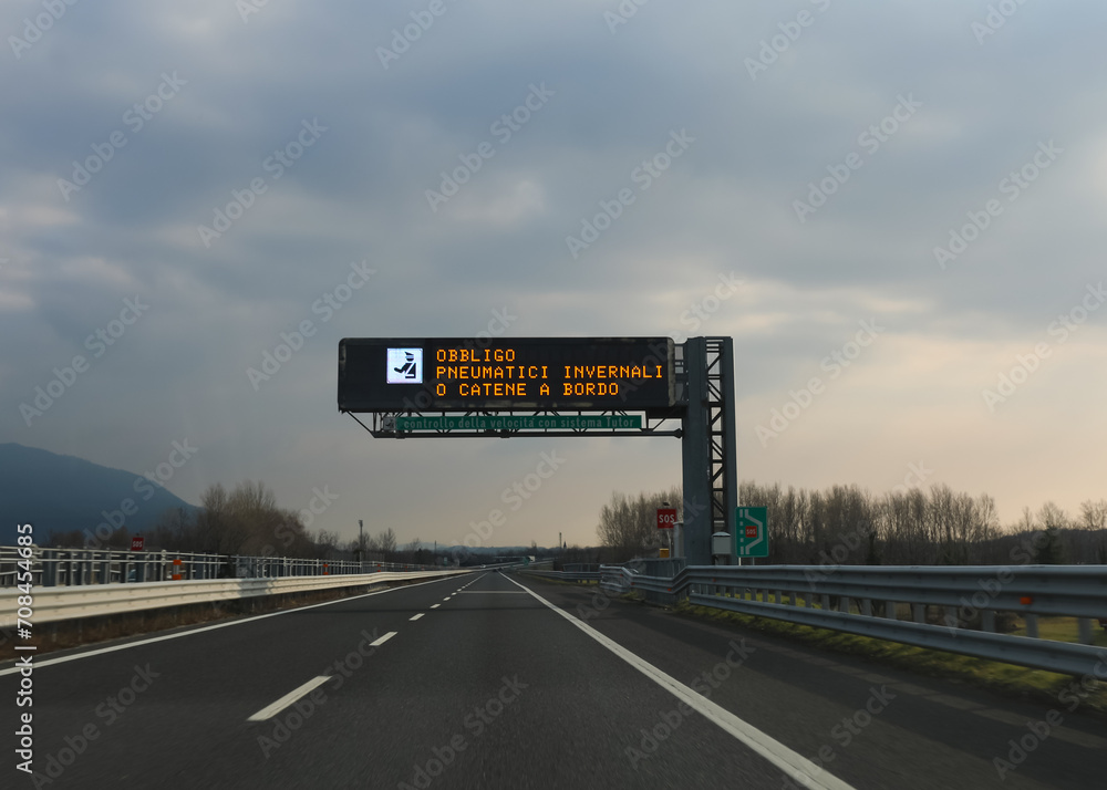 motorway sign indicating that it is mandatory to have snow chains and that there is an automatic speed detection system in Italy