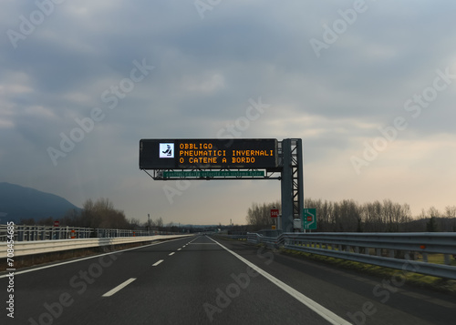 motorway sign indicating that it is mandatory to have snow chains and that there is an automatic speed detection system in Italy photo
