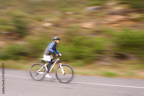 Man, mountain bike and cycling on road in speed for nature adventure or outdoor extreme sports. Male person or cyclist on bicycle for cardio, street or downhill in motion blur, exercise or practice