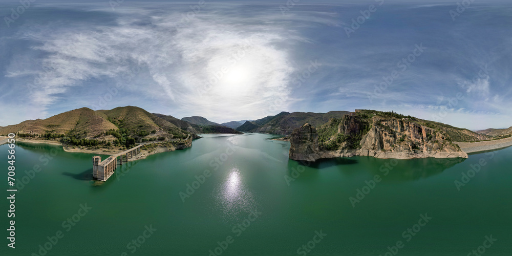 360 view. VR pano. Reservoir between mountains. Panoramic aerial view over the water of dam and dammed water between mountains. Water reservoir with colorful water color. Andalusia. Spain.