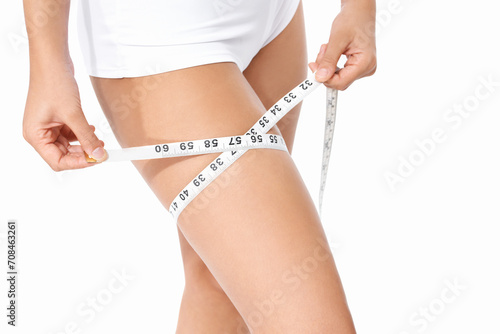 Woman, legs and tape measure for weight loss, slim body or health and wellness on a white studio background. Closeup of female person or model measuring thigh in diet, fitness or healthcare on mockup