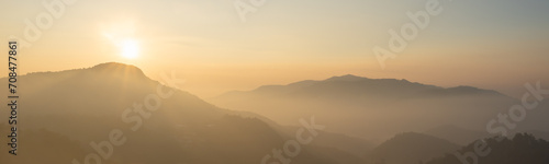 nature view of mountain forest landscape with sunrise and mist in the morning. Natural scenery outdoor travel background. 
